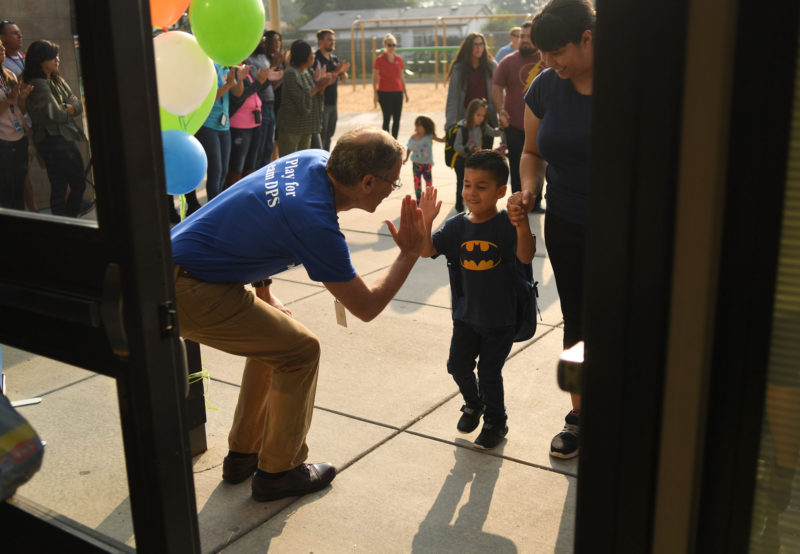 Damian Lopez, 4, gives Denver Public Schools Superintendent Tom Boabserg a high-five as he arrives for the first day of school at Escalante-Biggs Academy on August 20, 2018 in Denver, Colorado.